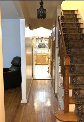 a view of entryway and kitchen with wooden floor