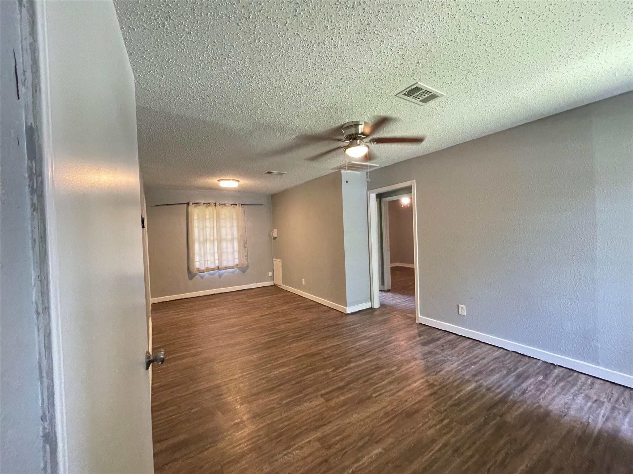 5213 Anzio Road Houston, TX 77033 - Photo 4 of 20 a view of an empty room with wooden floor