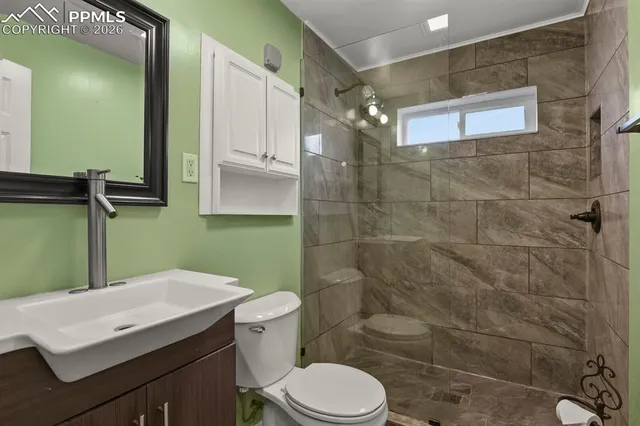 a bathroom with a sink a toilet and shower