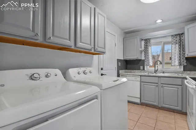 a utility room with sink dryer and washer