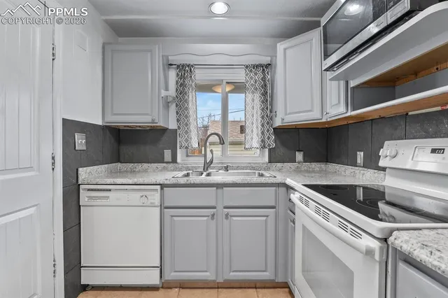 a kitchen with cabinets appliances a sink and a window
