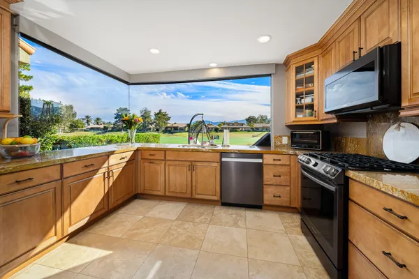 a kitchen with stainless steel appliances granite countertop a stove a sink and a microwave