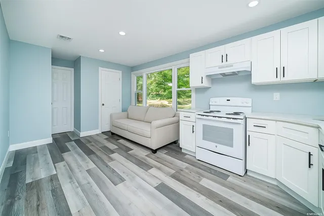 a kitchen with white cabinets and white appliances