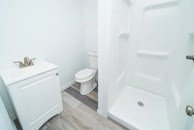 a bathroom with a sink a toilet and shower