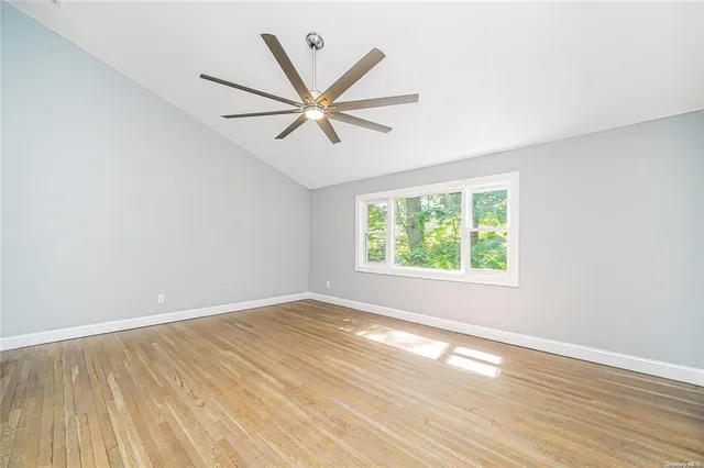 a view of a big room with wooden floor and windows