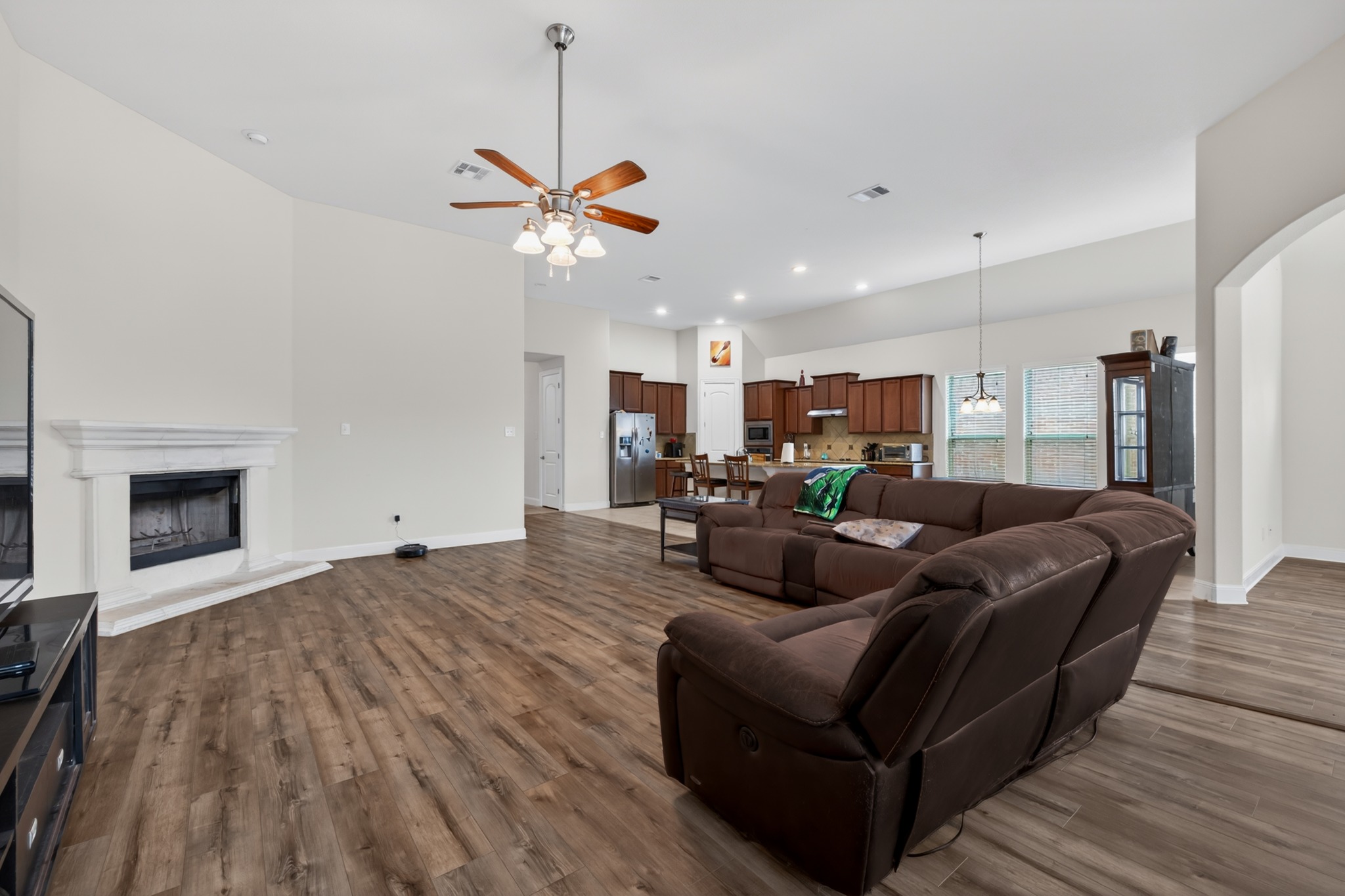 1017 Tabernash Leander, TX 78641 - Photo 18 of 38 Spacious living area featuring wood-finish flooring, a white mantel fireplace, and a ceiling fan with light fixture