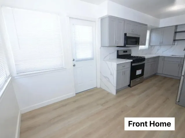 a kitchen with a sink stainless steel appliances a counter top space and cabinets