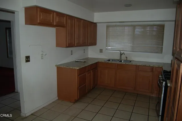 a kitchen with a sink a stove cabinets and wooden floor