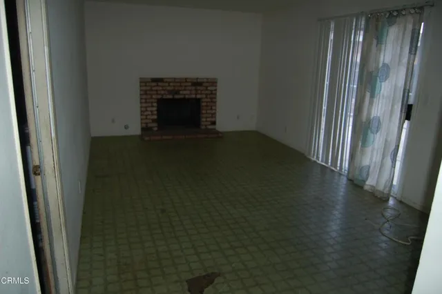 a view of a livingroom with wooden floor and a fireplace