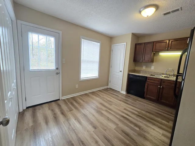a view of kitchen with granite countertop cabinets and wooden floor