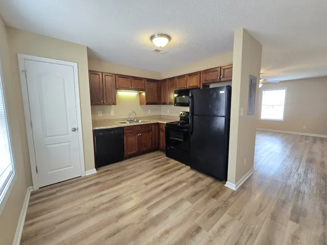 a kitchen with stainless steel appliances granite countertop a refrigerator and a sink