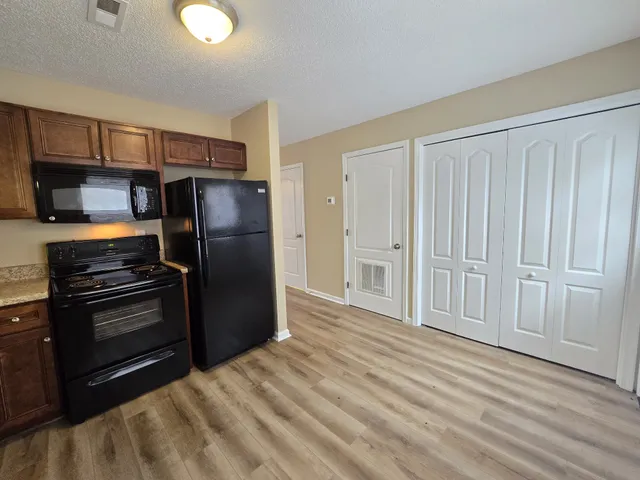 a kitchen with a refrigerator stove and cabinets