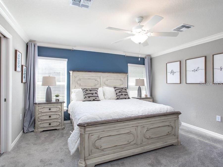 727 Southwest 77th Circle Ocala, FL 34474 - Photo 13 of 16 a bedroom with a bed and a chandelier