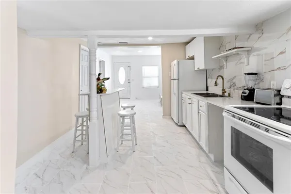 a kitchen with stainless steel appliances a white cabinet and a stove top oven