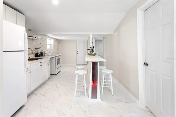 a kitchen with white cabinets and white appliances