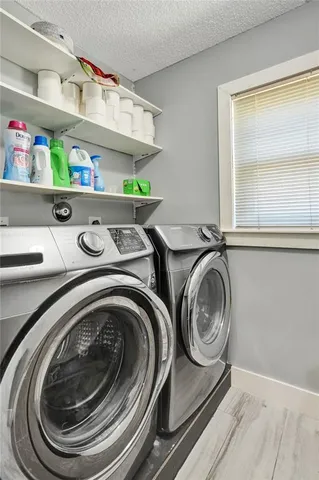 a kitchen with stainless steel appliances granite countertop a refrigerator a stove and a sink with wooden floor