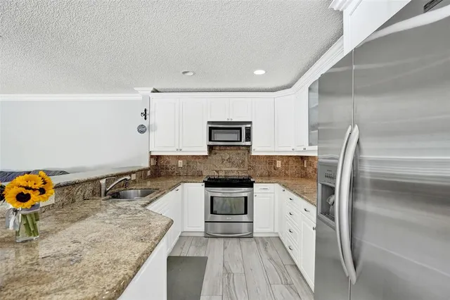 a kitchen with granite countertop a sink and cabinets