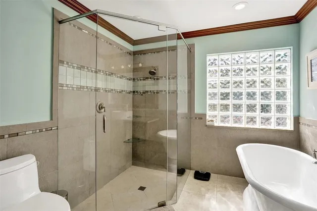 a bedroom with a bed a chair and a large window