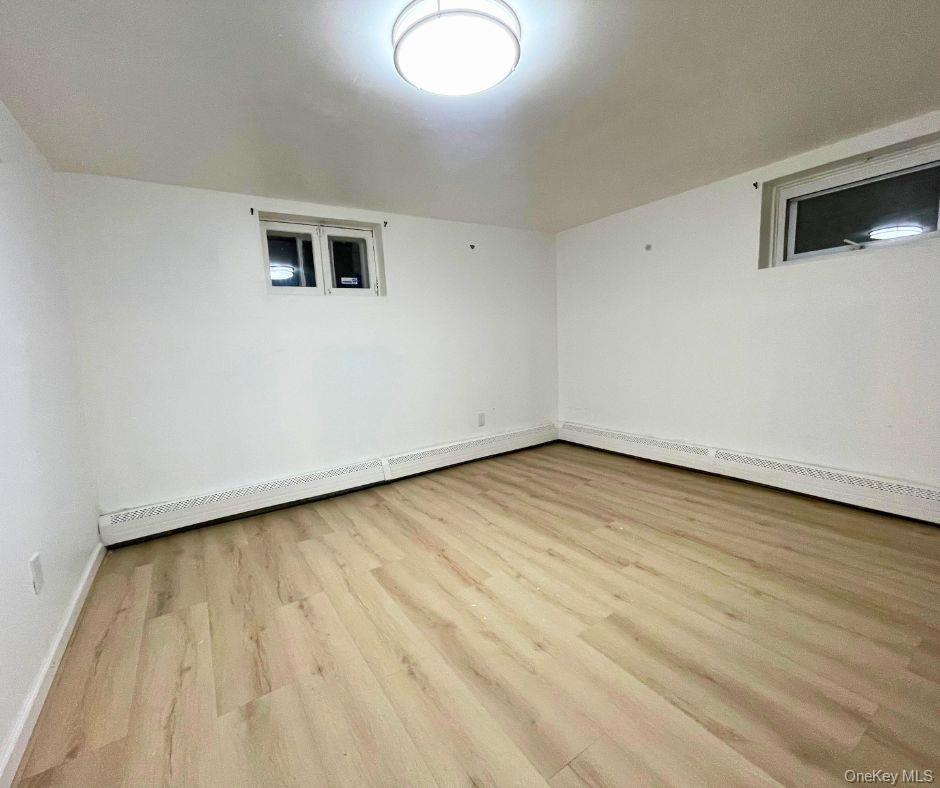 113-33 204th Street, Unit 3 Queens, NY 11412 - Photo 5 of 8 an empty room with wooden floor and windows