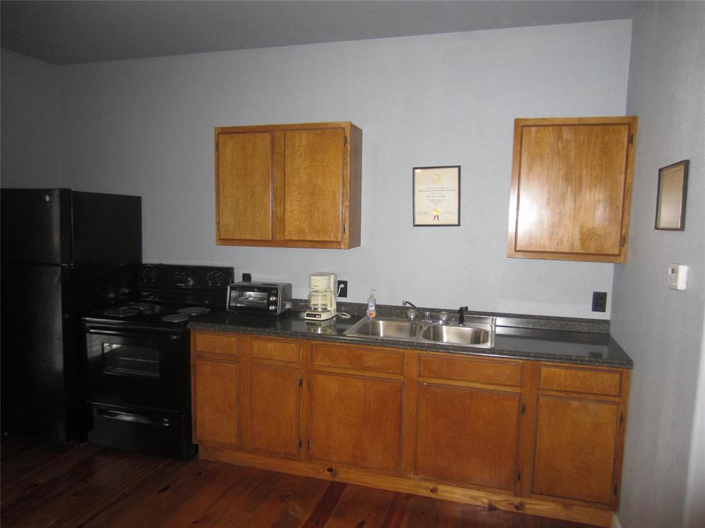1004 Church Street Sulphur Springs, TX 75482 - Photo 4 of 38 a kitchen with stainless steel appliances granite countertop a sink stove and refrigerator