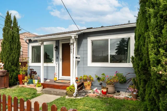 a view of a house with a small yard and wooden fence