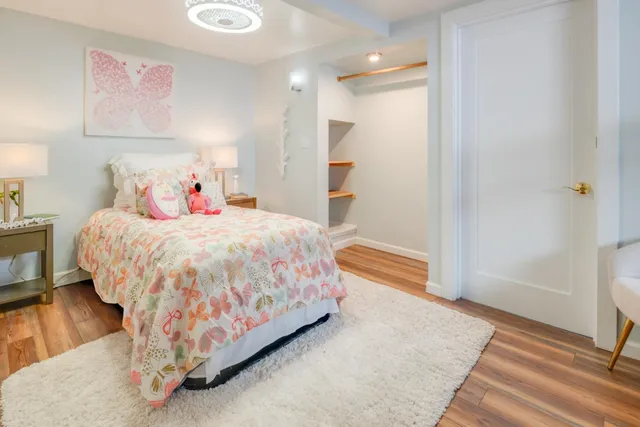 a bedroom with a bed and wooden floor