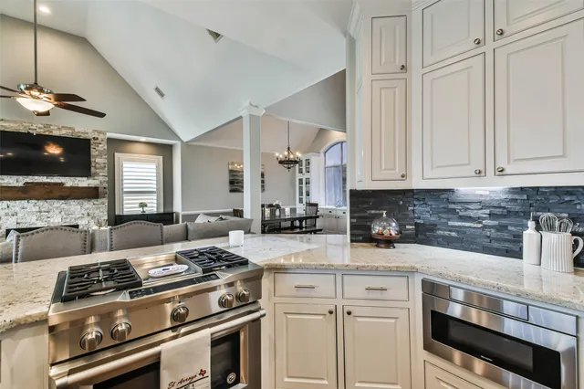 a kitchen with stainless steel appliances granite countertop a stove and a white cabinets