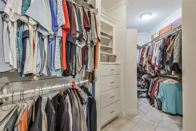 a view of walk in closet with clothes