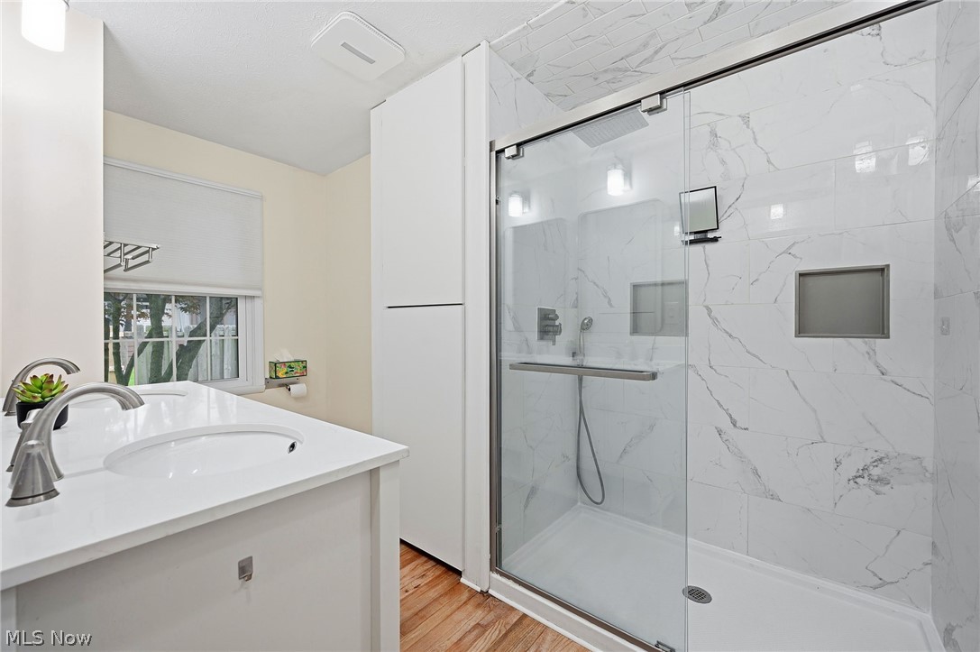 1515 Barlow Road Hudson, OH 44236 - Photo 22 of 31 Primary bedroom bathroom featuring walk-in shower, dual vanities, storage space and natural light.