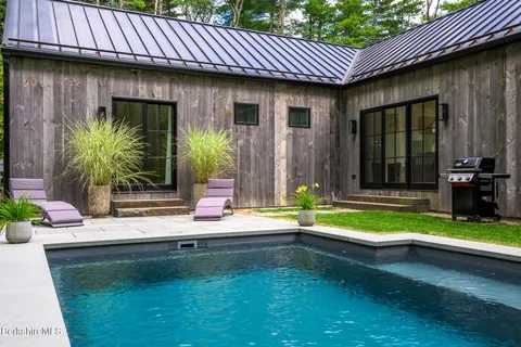 a view of swimming pool with a yard and large trees