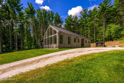 a view of a house with backyard and a tree