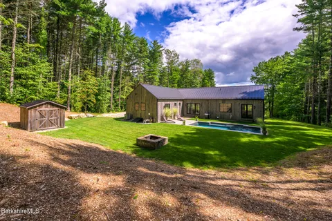 a front view of a house with a yard and green space