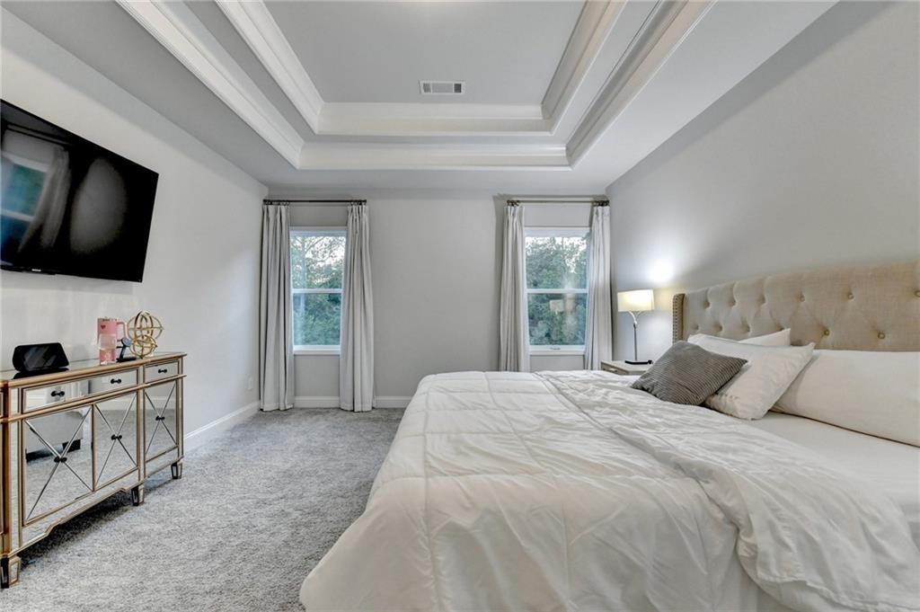 298 Ryston Way Grayson, GA 30017 - Photo 26 of 51 a bedroom with a large bed and a flat tv screen on dresser