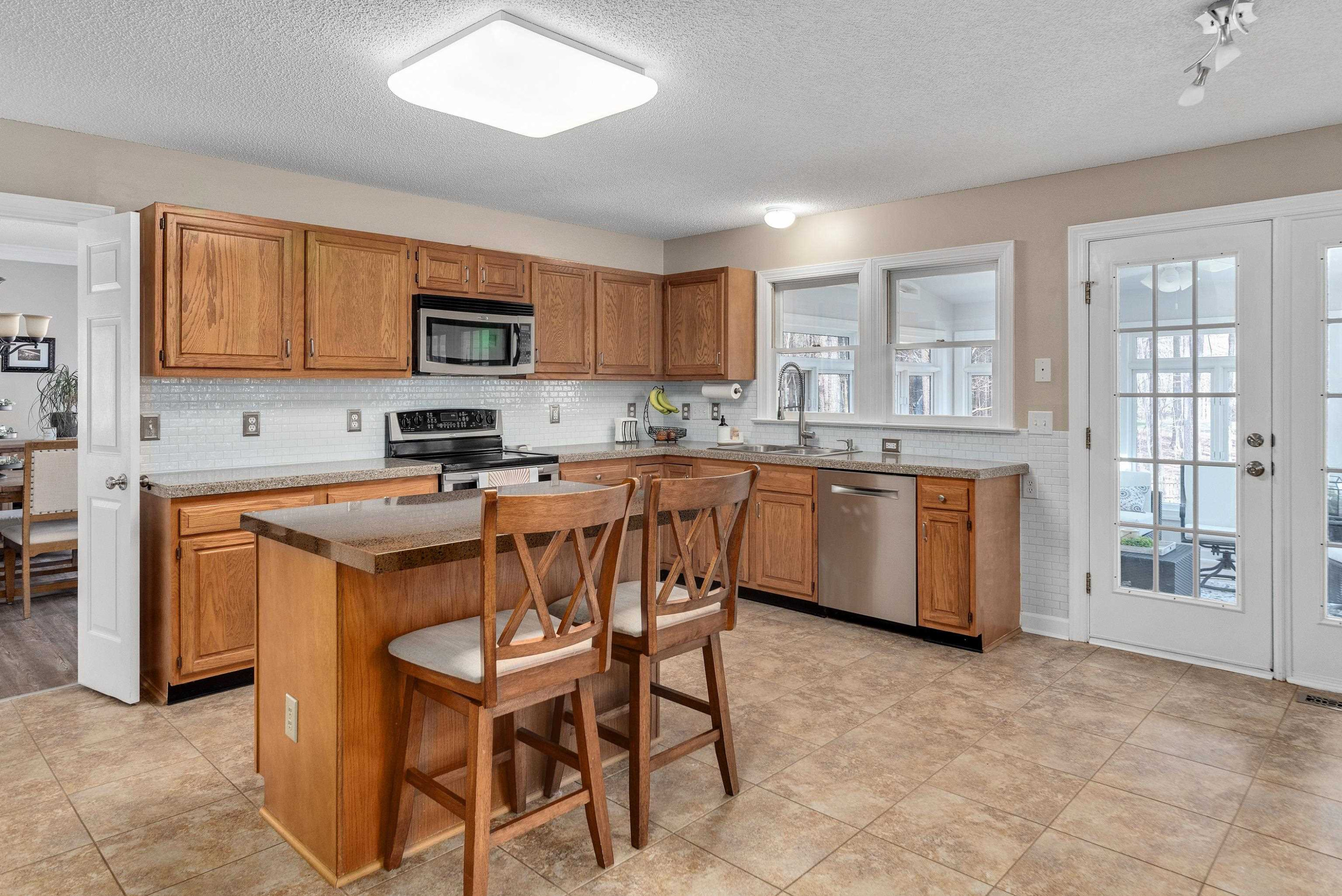 100 Moray Drive Raleigh, NC 27613 - Photo 7 of 32 a kitchen with stainless steel appliances granite countertop a stove a sink dishwasher a microwave oven and a refrigerator with wooden cabinets