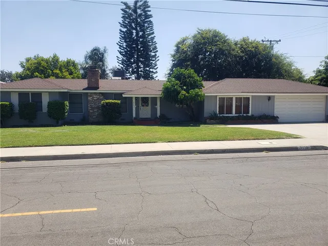 a front view of a house with a yard and potted plants