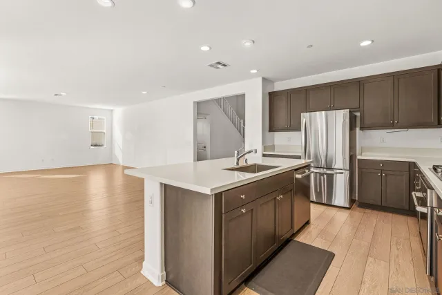 a kitchen with stainless steel appliances granite countertop a sink stove and refrigerator