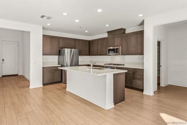 a kitchen with stainless steel appliances granite countertop a refrigerator and a stove top oven
