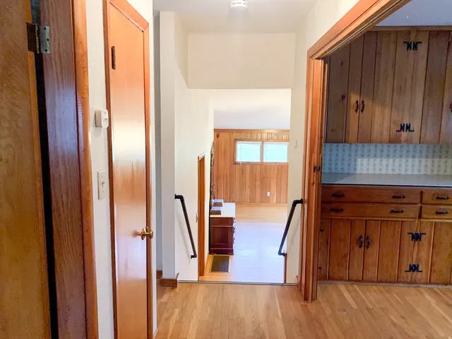 a view of a hallway with wooden floor and staircase