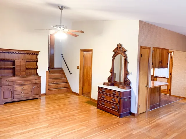 a view of a livingroom with wooden floor and stairs