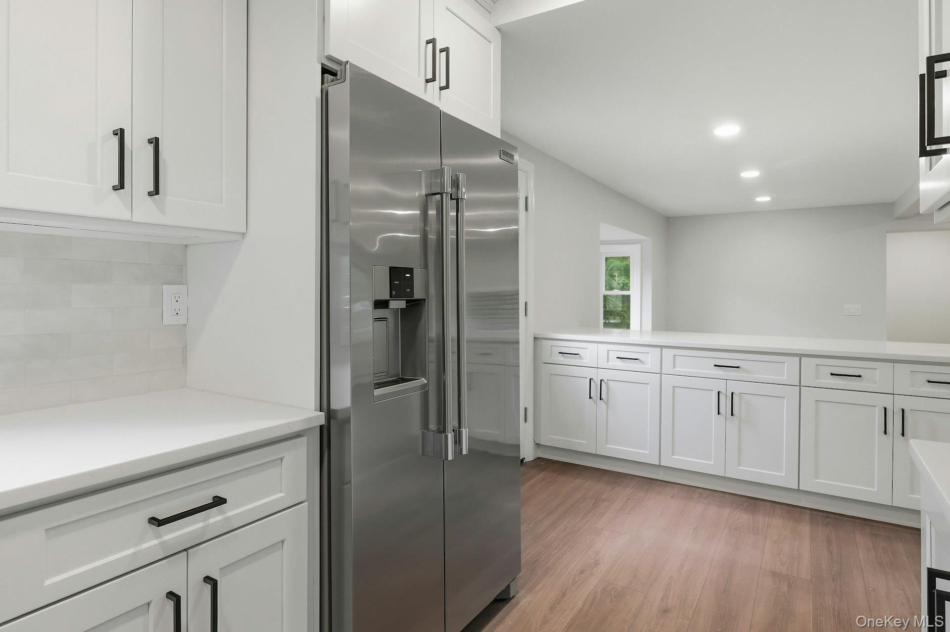 101 Rustic Road Centereach, NY 11720 - Photo 22 of 42 a kitchen with white cabinets and refrigerator