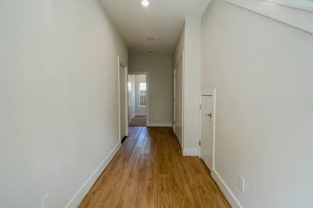 a view of a hallway with wooden floor
