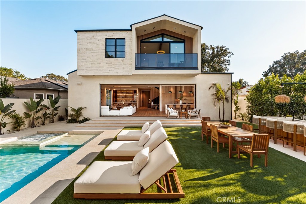 a view of a house with swimming pool and sitting area