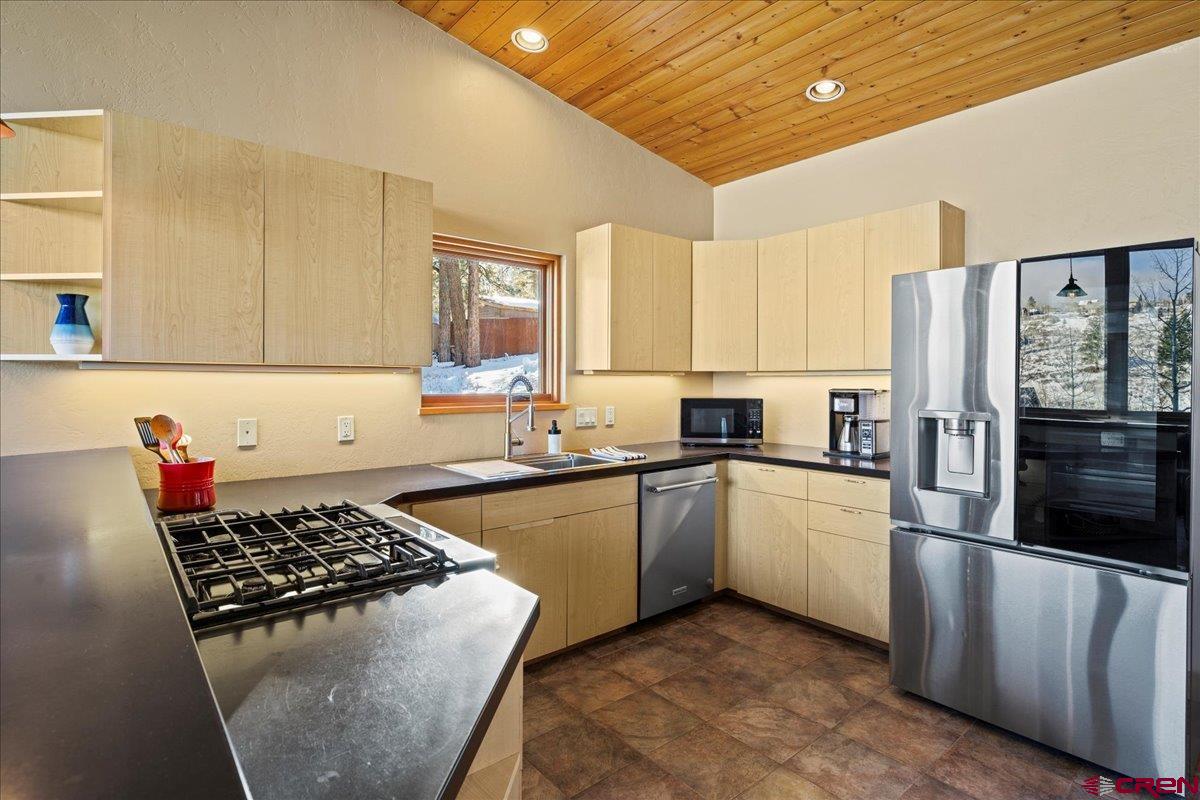 1578 Aspen Drive Ridgway, CO 81432 - Photo 26 of 45 a kitchen with stainless steel appliances granite countertop a stove a sink dishwasher and a refrigerator