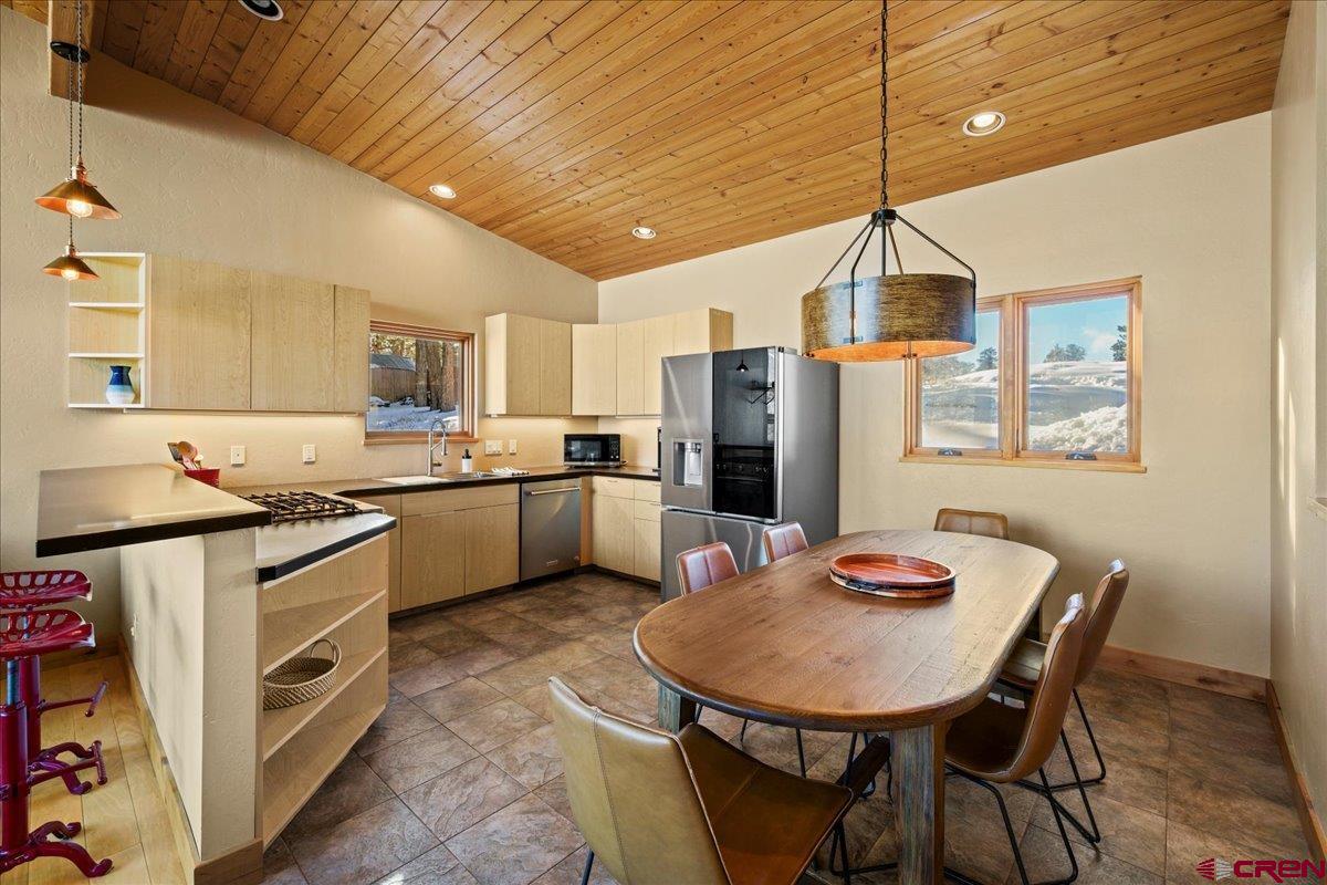 1578 Aspen Drive Ridgway, CO 81432 - Photo 37 of 45 a kitchen with stainless steel appliances kitchen island granite countertop a sink dishwasher a refrigerator a stove a kitchen island with a dining table and chairs