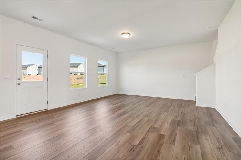 2115 Boxwood Circle Conyers, GA 30013 - Photo 12 of 42 an empty room with wooden floor and windows