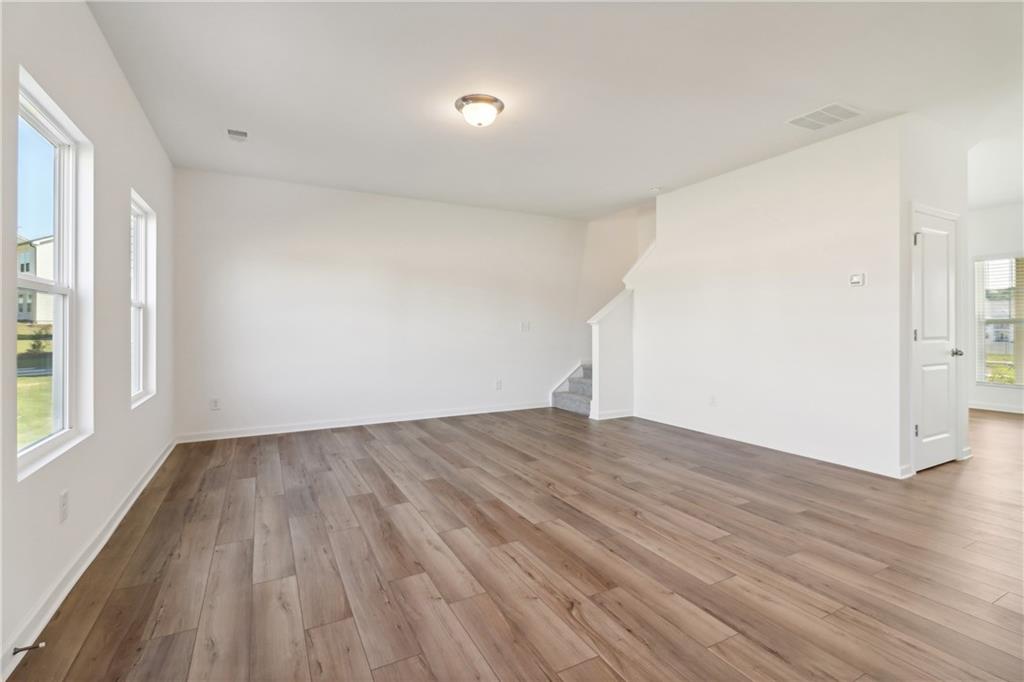 2115 Boxwood Circle Conyers, GA 30013 - Photo 13 of 42 an empty room with wooden floor and windows