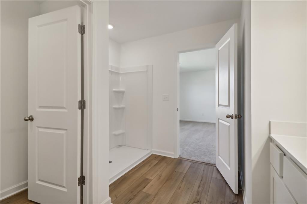 2115 Boxwood Circle Conyers, GA 30013 - Photo 20 of 42 a view of a hallway with wooden floor and a bathroom