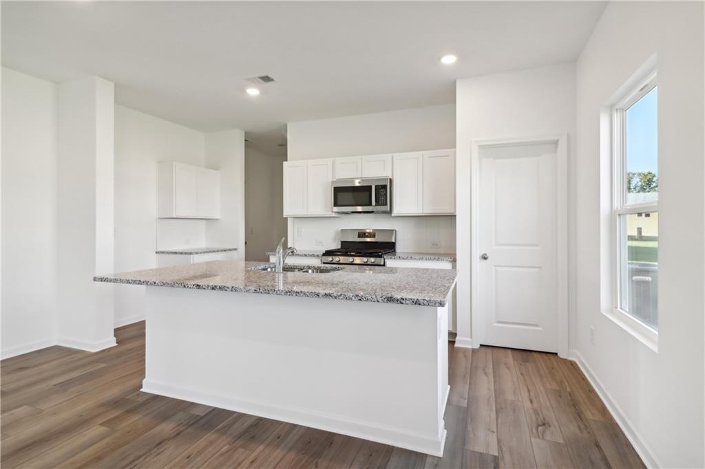2115 Boxwood Circle Conyers, GA 30013 - Photo 7 of 42 a kitchen with stainless steel appliances granite countertop a stove a sink and a refrigerator