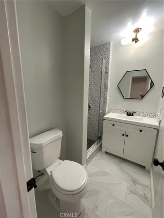 a bathroom with a toilet a sink and mirror