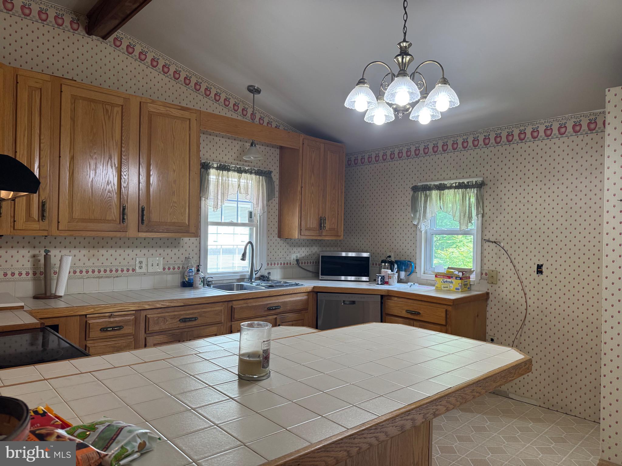 304 Cool Hollow Road Falling Waters, WV 25419 - Photo 19 of 42 a kitchen with a stove a sink a dining table and chairs